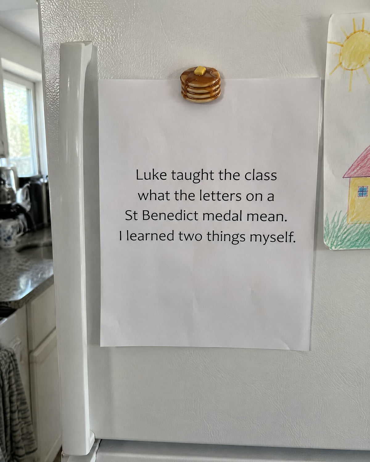 A note on the refrigerator under a pancake magnet: Luke taught the class what the letters on a St Benedict medal mean