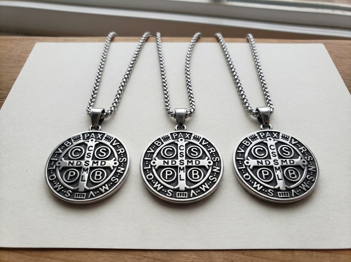Three St Benedict medals side by side on their chains
