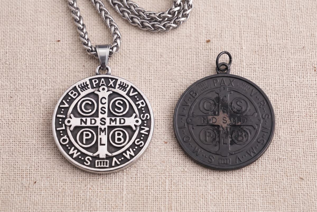 Our St Benedict medal beside a flat black store medal of the same size