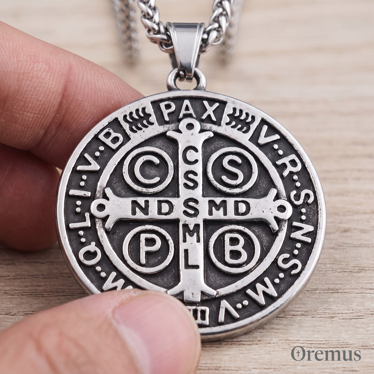 A thumb on the St Benedict medal, every letter readable