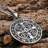 The St Benedict medal in polished steel on its chain, cross side up