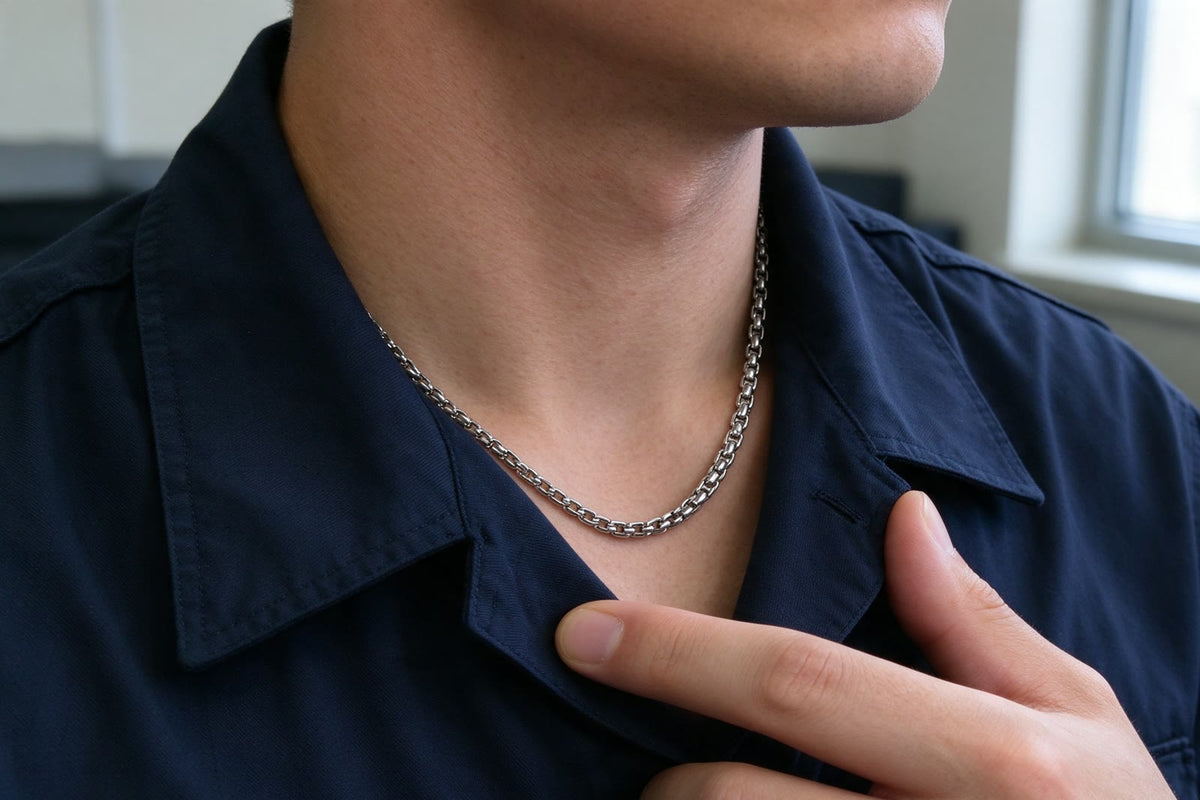 A man’s finger pulling his uniform collar aside, a steel chain underneath