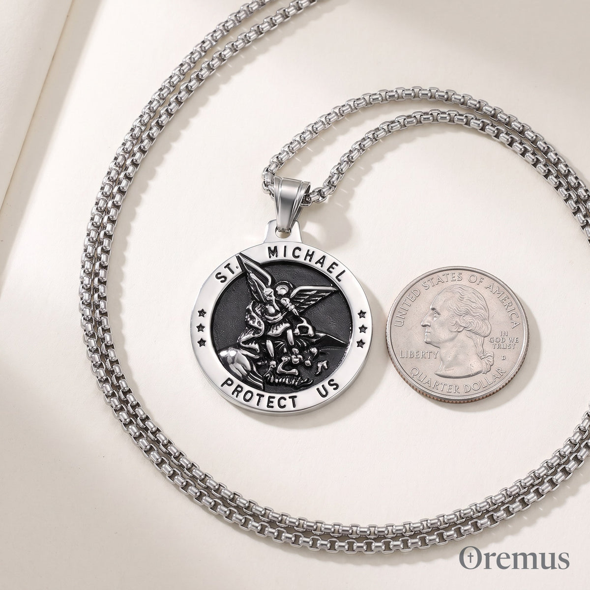 The St Michael medal in silver beside a quarter